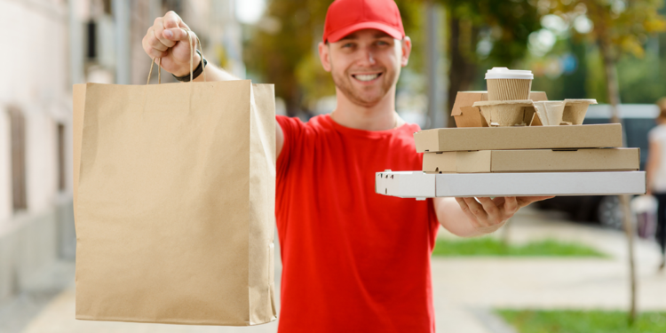 Um entregador sorridente segurando uma caixa, representando a eficiência e a satisfação do fast delivery no comércio moderno.